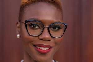 Headshot of Mona-Lee Belizaire. Black woman with short brown hair and glasses.