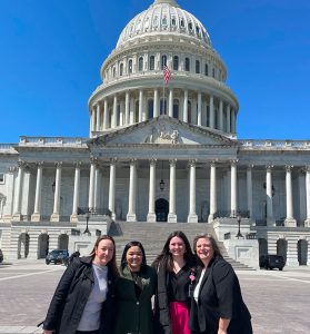 AWIS members Eleni Bachlava, Kiara Dominique Wiggins, Sydney Woods, and AWIS CEO Meredith Gibson in front of the US Capitol building