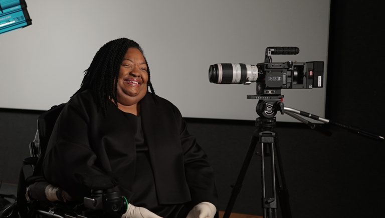 Crystal R. Emery is smiling, surrounded by film equipment