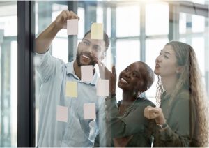 group of diverse people putting notes on a glass wall