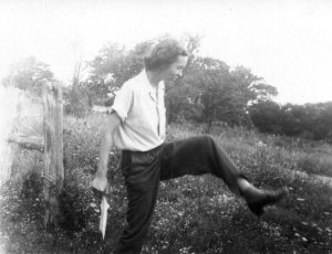 Black and white photo of Elsie Quarterman in 1947 outside stepping over plants